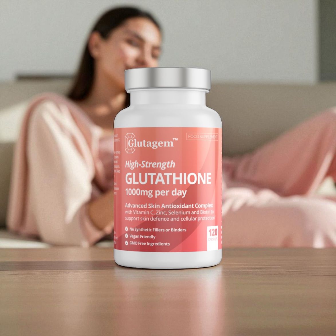 Bottle of Glutagem High-Strength Glutathione supplement on a table with a blurred woman in the background.