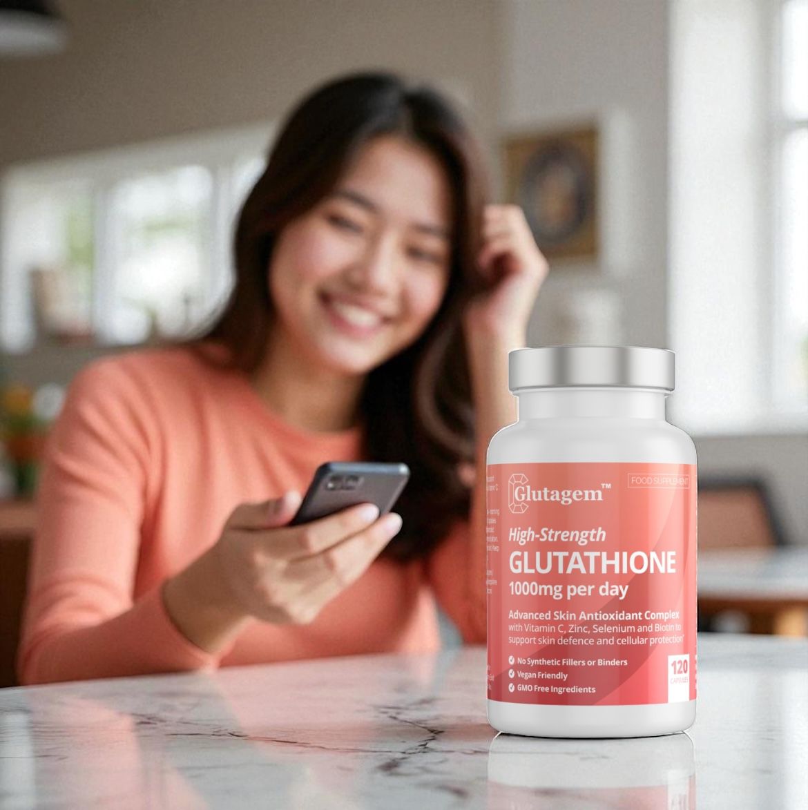 Woman using a smartphone with a Glutagen Glutathione supplement bottle on a table.