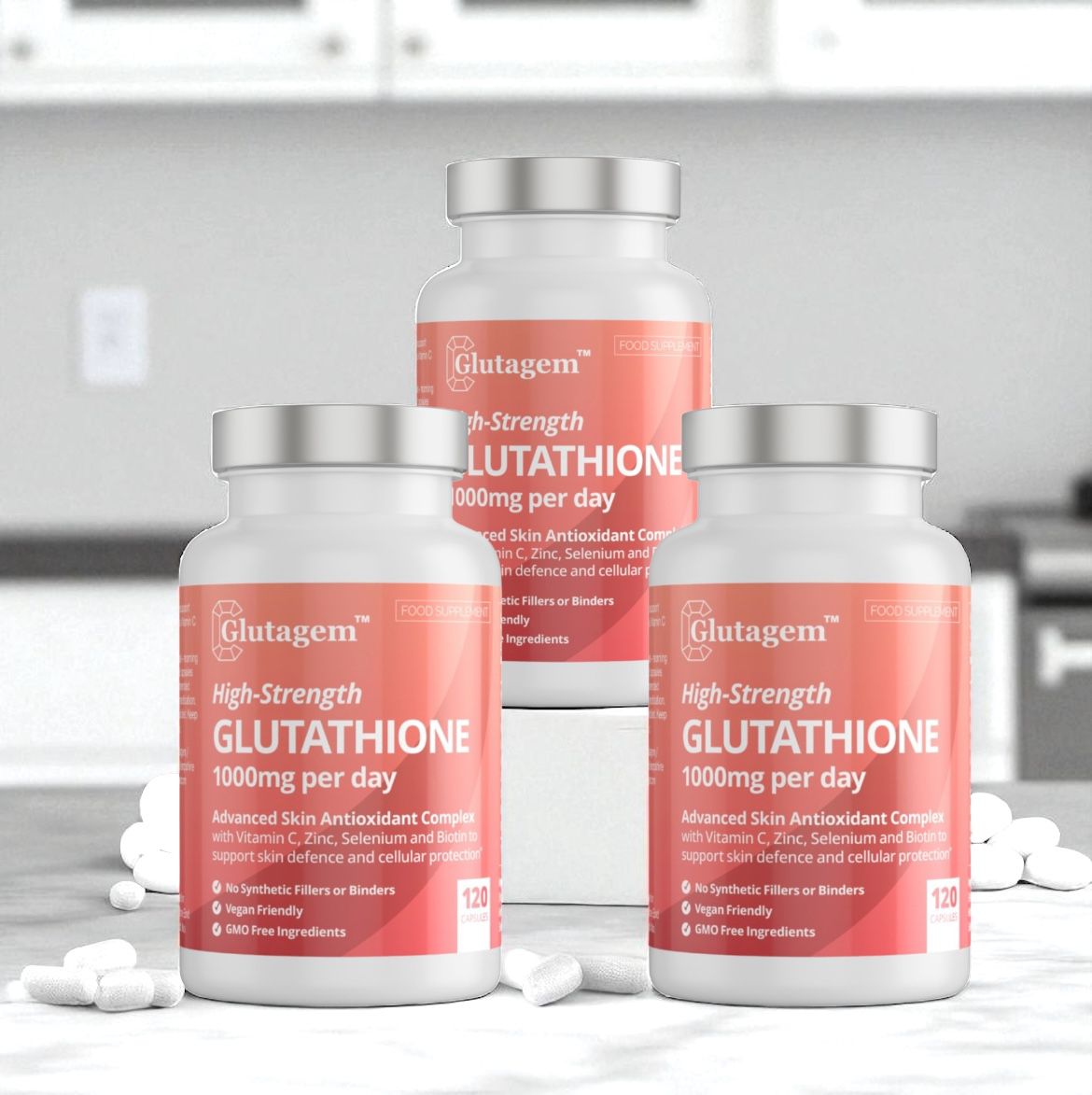 Three bottles of Glutagem High-Strength Glutathione supplements on a white surface with a blurred kitchen background. Discount offer for multi-packs. 